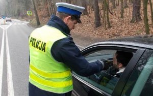 Policjant bada trzeźwość kierującego pojazdem