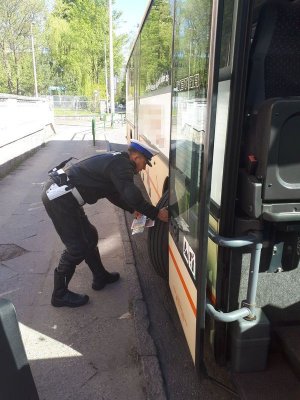 policjant kontroluje stan techniczny autokaru