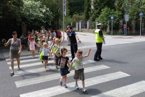 policjanci i dzieci ćwiczą właściwe przechodzenie przez przejście dla pieszych