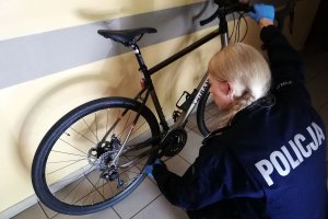 policjantka przeprowadza oględziny odzyskanego roweru