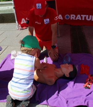Stoisko sopockiego WOPR-u - ratownik uczy czynności udzielania pierwszej pomocy