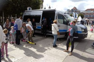 Festyn - policjantka rozmawia z osobami i pokazuje im radiowóz