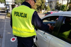 policjant kontroluje trzeźwość kierowcy auta