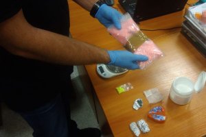 policjant dokonuje oględzin zabezpieczonych narkotyków