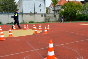 policjant obserwuje i ocenia przejazd uczestnika turnieju