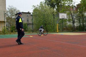 policjant obserwuje i ocenia przejazd uczestnika turnieju