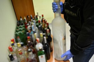 policjant zabezpiecza napoje alkoholowe