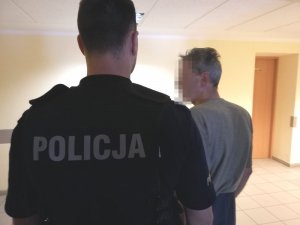 policjant prowadzi zatrzymanego