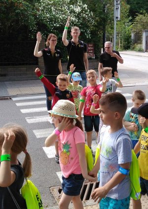 policjanci i dzieci ćwiczą właściwe przechodzenie przez przejście dla pieszych