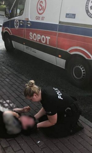 policjantka udziela pomocy rannej kobiecie