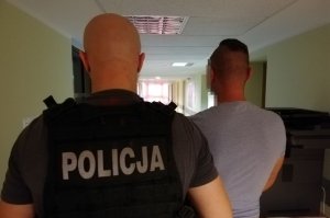 policjant prowadzi zatrzymanego