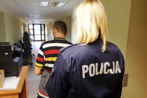 policjantka prowadzi zatrzymanego