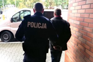 policjant prowadzi zatrzymanego