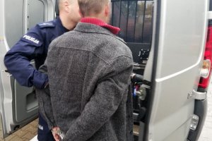 policjant prowadzi zatrzymanego