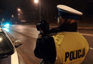 Policjant mierzy prędkość jadących pojazdów - zdjęcie poglądowe