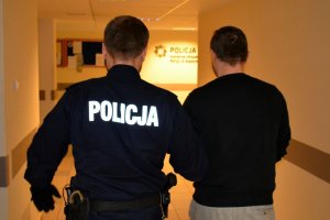 policjant prowadzi zatrzymanego