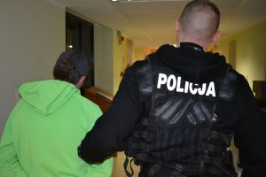 policjant prowadzi zatrzymanego