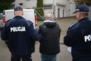 policjanci prowadzą zatrzymanego