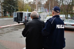 policjant prowadzi zatrzymanego