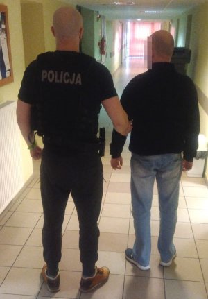 policjant prowadzi zatrzymanego