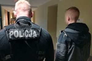 policjant prowadzi zatrzymanego