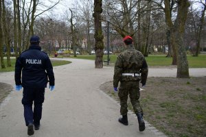 policjant i żołnierz patrolują park