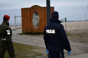 policjant i żołnierz patrolują okolice plaży