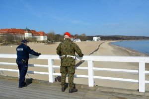 policjant z żołnierzem patrolują pas nadmorski