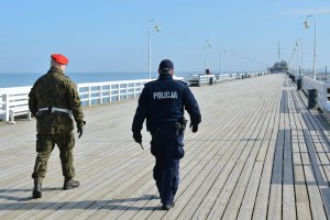 policjant z żołnierzem patrolują teren