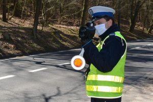 Policjant z tzw. lizakiem mierzy prędkość pojazdów.