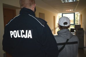 policjant prowadzi zatrzymanego