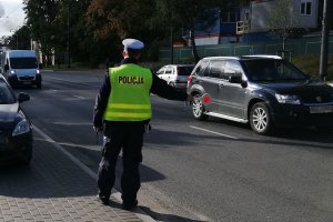 policjant zatrzymuje pojazd do kontroli drogowej