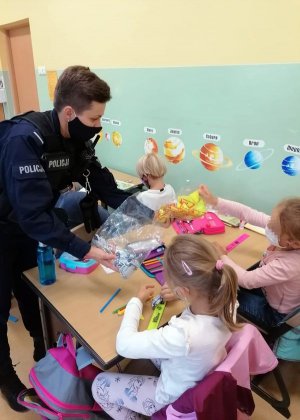 policjantka rozdaje dzieciom odblaski