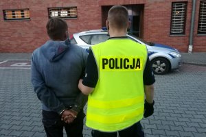 policjant prowadzi zatrzymanego