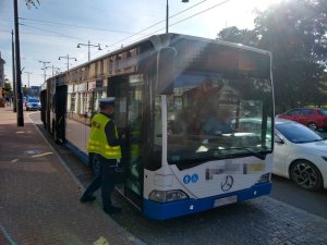 policjant kontroluje autobus