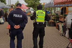 policjant ze strażnikiem miejskim kontrolują rynek