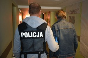 policjant prowadzi zatrzymanego