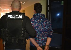 policjant prowadzi zatrzymanego