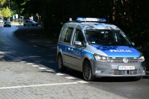 policjanci w radiowozie jadą ulicą i patrolują rejon