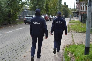 policjanci idą chodnikiem i kontrolują okolicę - zdjęcie archiwalne