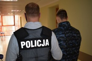 policjant prowadzi zatrzymanego mężczyznę