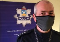 Na zdjęciu umundurowany policjant - nadkomisarz Piotr Went. Za nim w tle widoczne na ścianie logo Komendy Miejskiej Policji w Sopocie