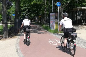 Umundurowani policjanci jadą na rowerach drogą dla rowerów. Zdjęcie archiwalne.