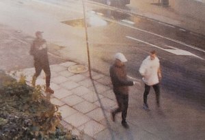 Trzech mężczyzn idzie po chodniku znajdującego się wzdłuż ulicy