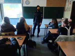 Policjantka umundurowana rozmawia z uczniami w klasie.