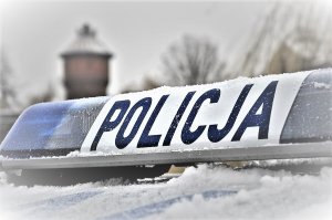 Ośnieżone światła z napisem POLICJA, które znajdują się na oznakowanym radiowozie.