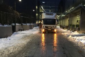 Pora nocna, deptak przy budynku. Pojazd ciężarowy stoi na drodze dla pieszych.