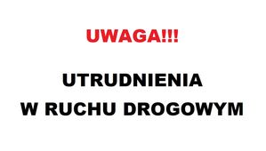 Na białym tle na górze czerwony napis o treści: UWAGA!!! Poniżej w dwóch rzędach czarny napis o treści: UTRUDNIENIA W RUCHU DROGOWYM.