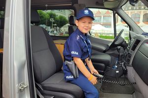 Dziecko w stroju policyjnym siedzi w samochodzie
