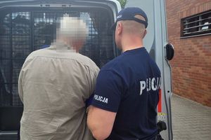 Na zdjęciu umundurowany policjant i zatrzymany mężczyzna w stoju cywilnym